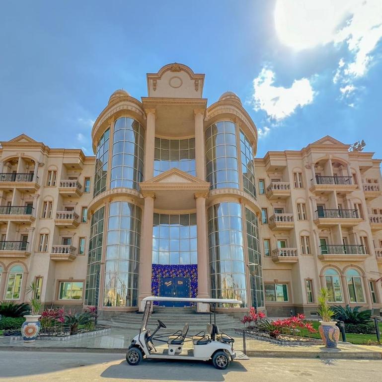 um carrinho de golfe estacionado em frente a um grande edifício em Ramage Hotel & Resort em Cairo