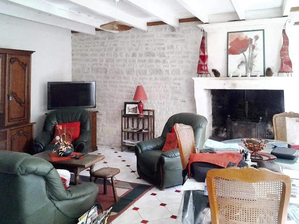 a living room with green chairs and a fireplace at Maison de 3 chambres avec jardin clos et wifi a Fleurac in Fleurac