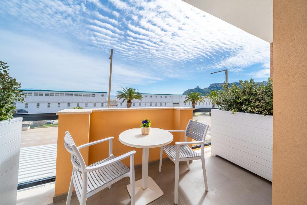 patio ze stołem i krzesłami na balkonie w obiekcie Poseidon Rooms w Cagliari
