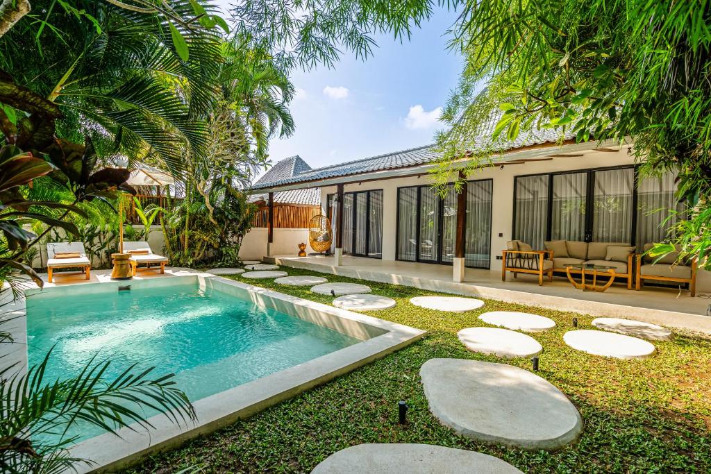 an external view of a villa with a swimming pool at Berapi Villa by EVDEkimi - Elegant 3BR Ubud Home with Pool & Kitchen near Central Ubud in Ubud