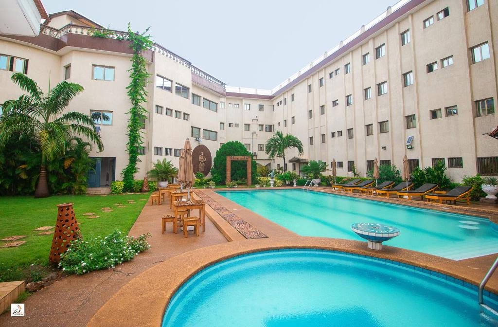 a large swimming pool in front of a building at Hotel le Pelican in Lomé