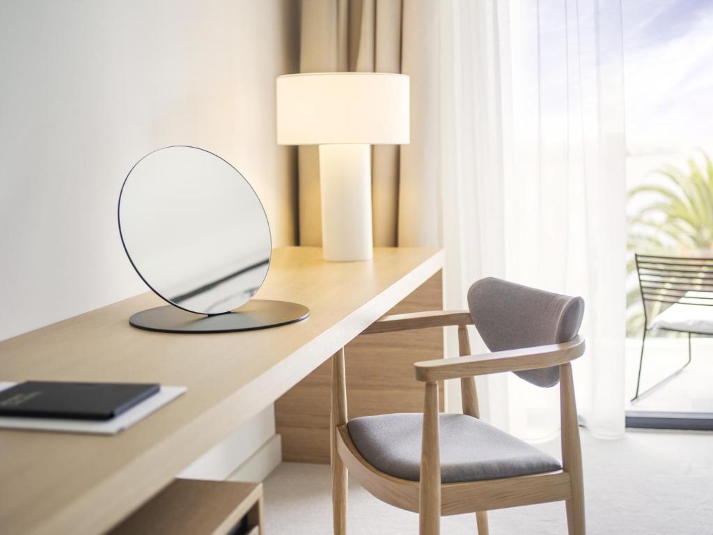 a desk with a chair and a mirror on it at Hotel Kompas in Dubrovnik