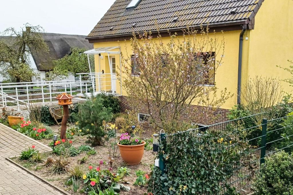 a garden in front of a yellow house at Ferienwohnung Balmer Wiesen in Balm