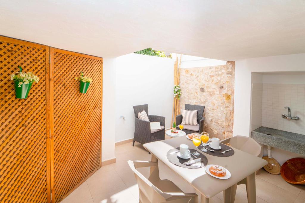ein Wohnzimmer mit einem Tisch und einem Esszimmer in der Unterkunft Townhouse Lleo 72 By homevillas360 in Pollença