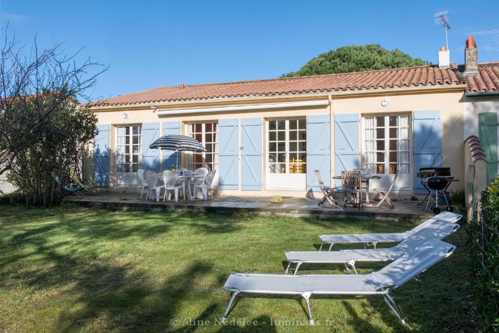 a house with two lawn chairs in the yard at La villa Laurette - Maison de vacances familiale in Île dʼAix