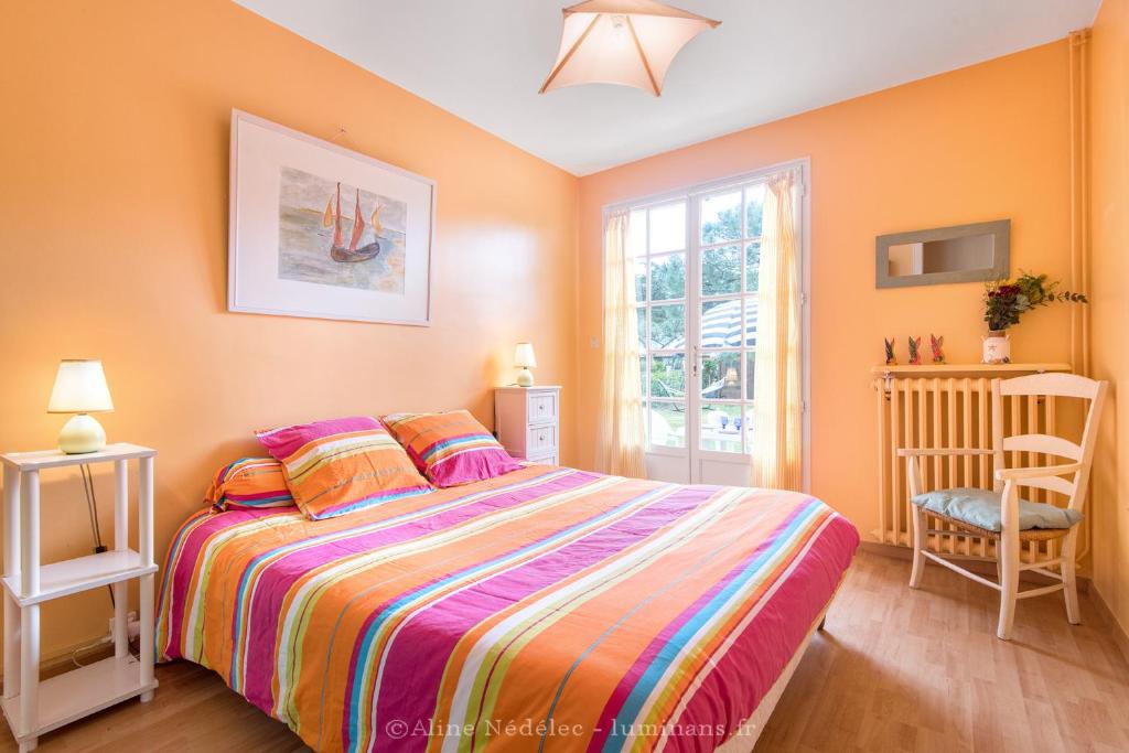 a bedroom with a large bed and a window at La villa Laurette - Maison de vacances familiale in Île dʼAix