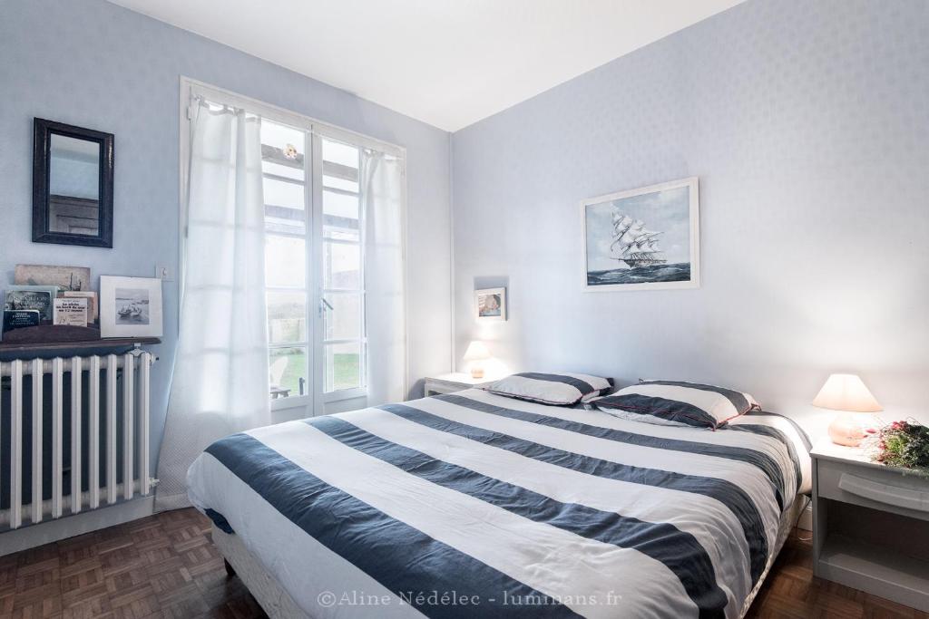 a bedroom with a large bed and a window at La villa Laurette - Maison de vacances familiale in Île dʼAix