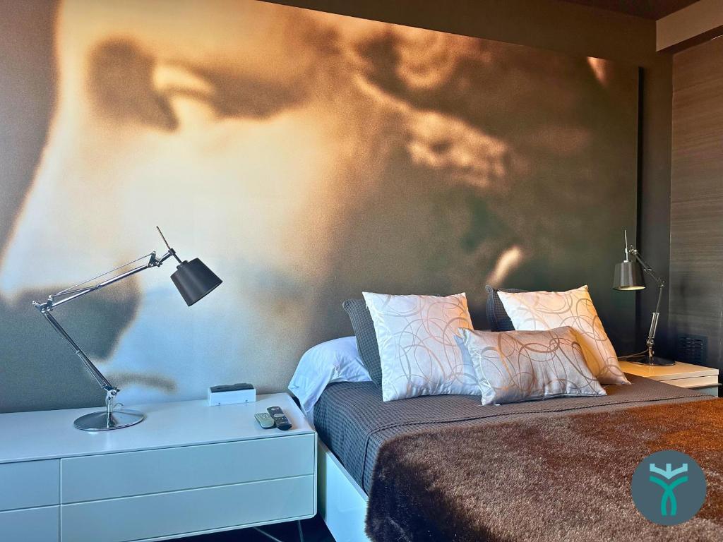 Schlafzimmer mit einem Bett mit Wandgemälde in der Unterkunft Dos Torres Silver in Saragossa