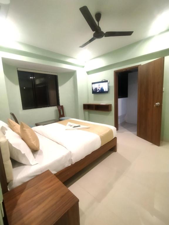 a bedroom with a bed with a ceiling fan at Everest Stays Rooms and Dormitory in Mumbai