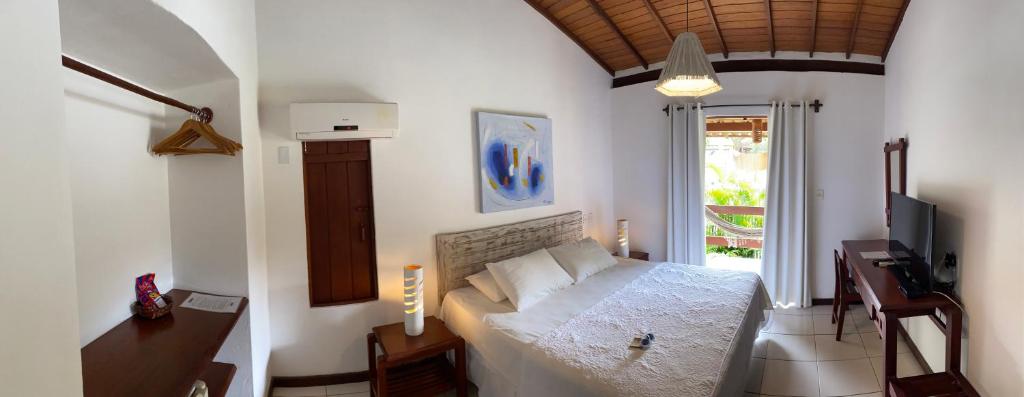 sypialnia z łóżkiem i telewizorem w obiekcie Pousada Coisa e Tao w mieście Arraial d'Ajuda
