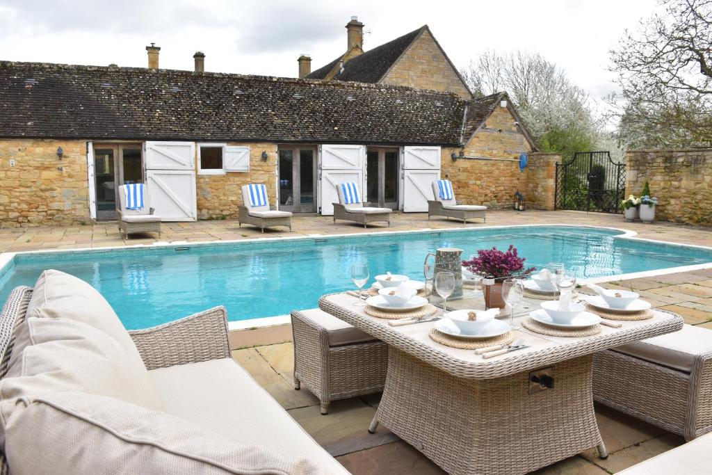 a patio with a table and chairs next to a pool at Foxholme Manor in Broadway
