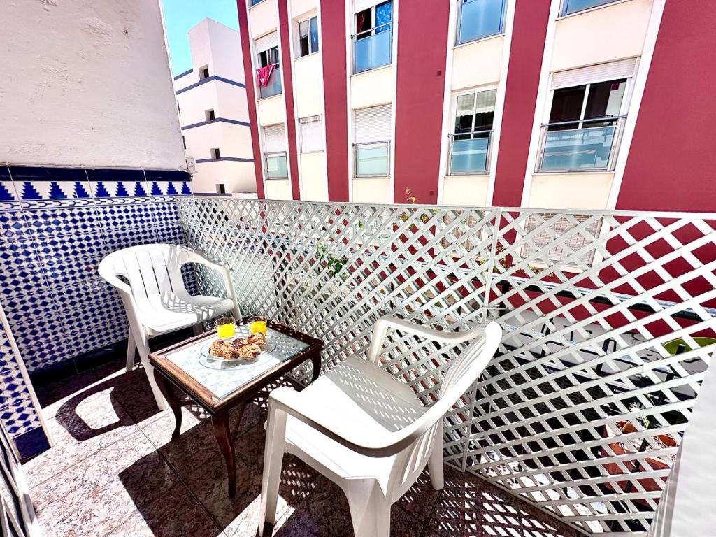 eine Terrasse mit 2 Stühlen und einem Tisch auf dem Balkon in der Unterkunft Centrico Apartamento Rincon de la Victoria , cerca de la Playa in Rincón de la Victoria