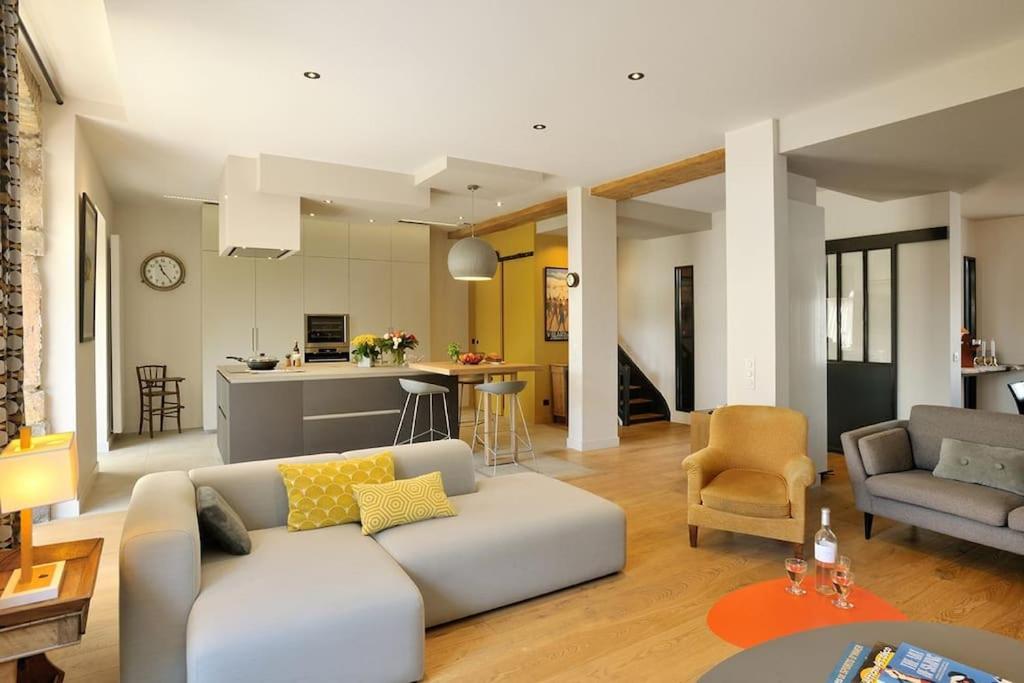 ein Wohnzimmer mit einem weißen Sofa und einer Küche in der Unterkunft Magnifique Villa, idéal famille Ste Foy Les Lyon in Sainte-Foy-lès-Lyon
