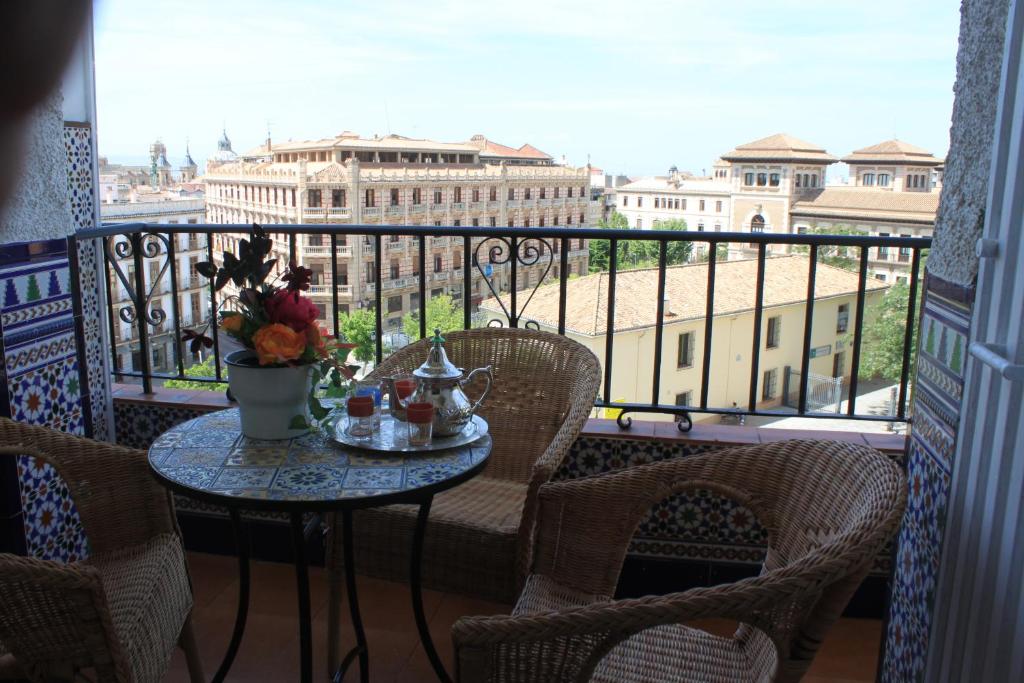 a table on a balcony with a view of the city at Apartamentos Vado - Arco de Elvira in Granada