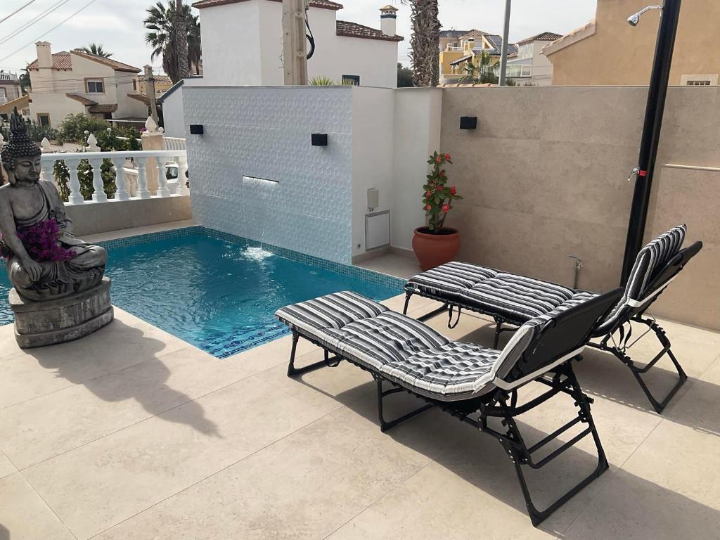 un par de sillas y una mesa junto a la piscina en Casa Sortino Rizzo en San Miguel de Salinas