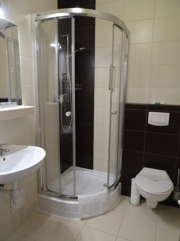 a bathroom with a shower and a toilet and a sink at Hotel Maksymilian in Krakow