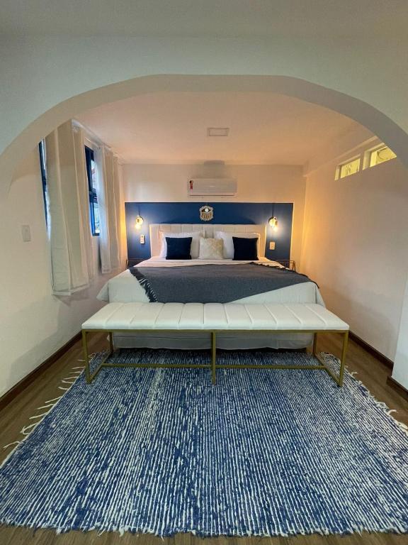 a bedroom with a large bed and a large rug at Cinque Terre Pousada & Bistrô in Rio de Janeiro