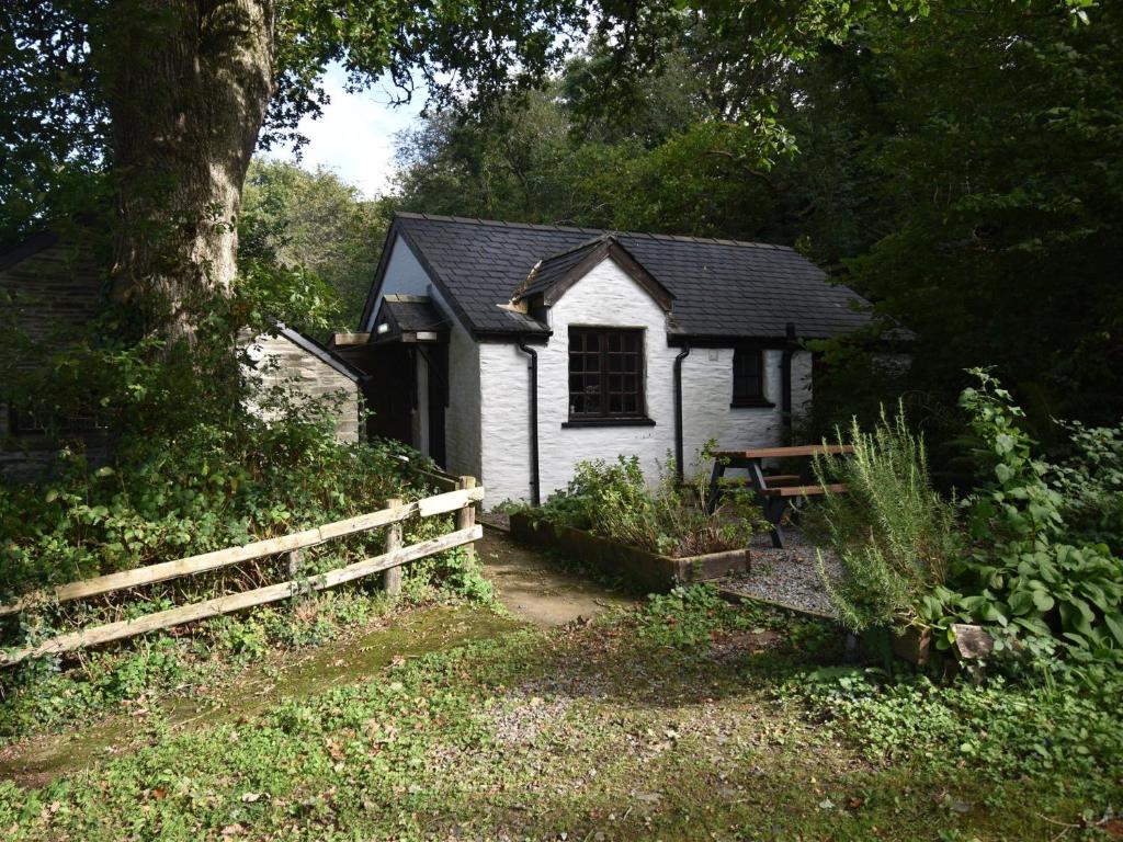 una pequeña casa blanca con una valla y un árbol en 2 Bed in Cilgerran FB173 en Cilgerran