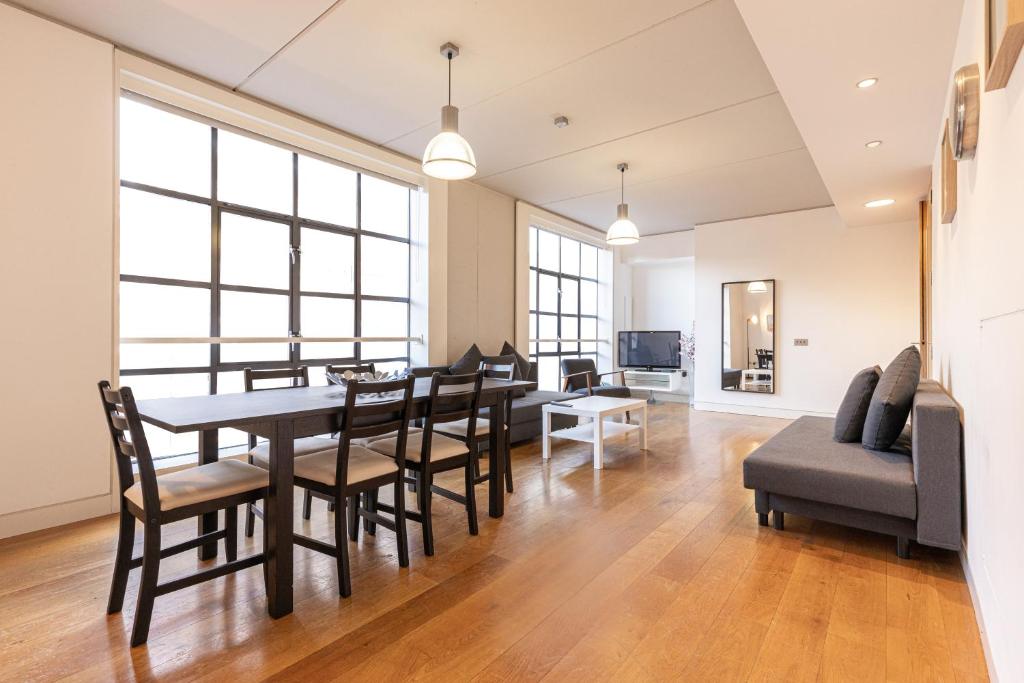comedor y sala de estar con mesa y sillas en City Centre Apartments Shoreditch, en Londres