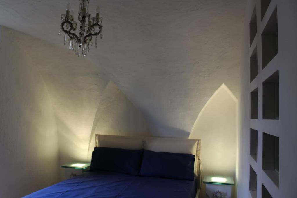 Schlafzimmer mit einem Bett und einem Kronleuchter in der Unterkunft Casa Palma in Copertino