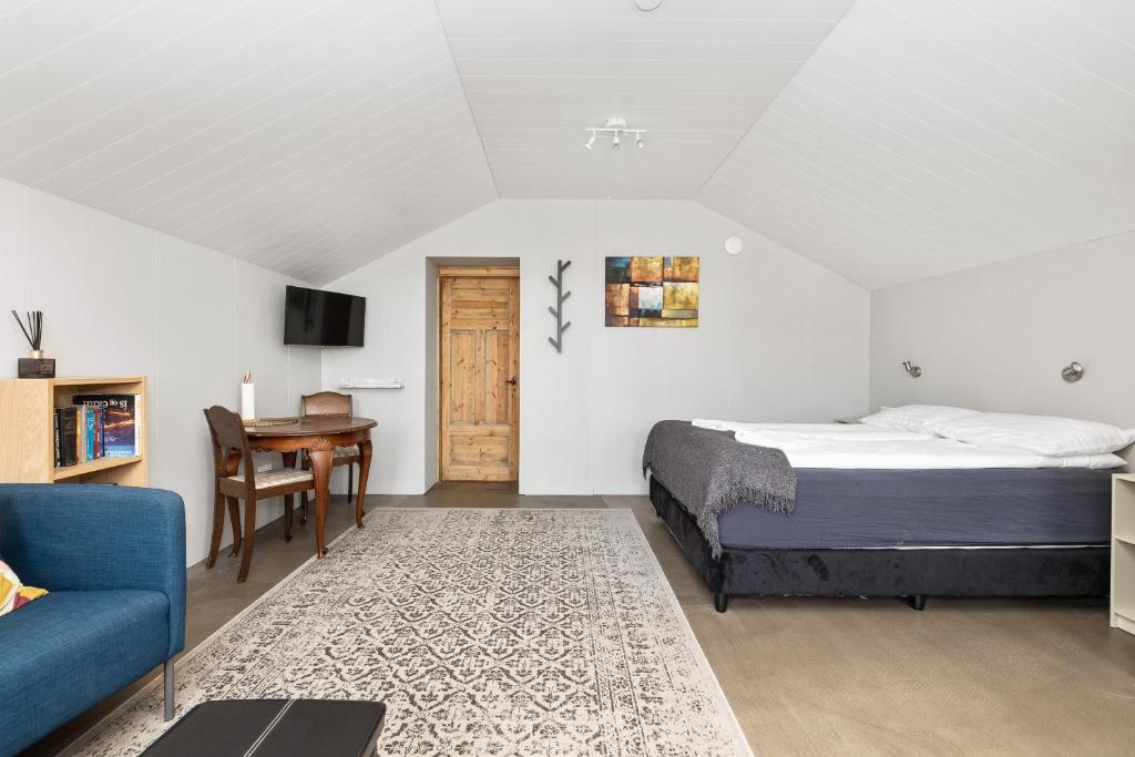 una camera con letto, tavolo e divano di Rauðafell ChickenCoop a Skogar
