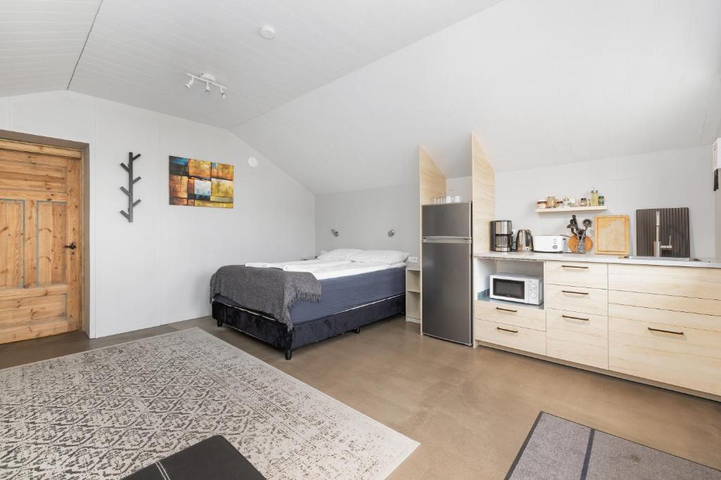 una camera con letto e frigorifero e una cucina di Rauðafell ChickenCoop a Skogar