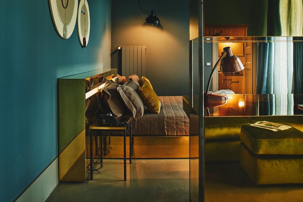 una persona sdraiata su un letto in una stanza di Boutique Hotel Borgo Nuovo a Milano