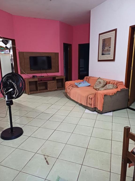 um quarto com uma cama e uma televisão de ecrã plano em Casa Itaúnas em Itaúnas