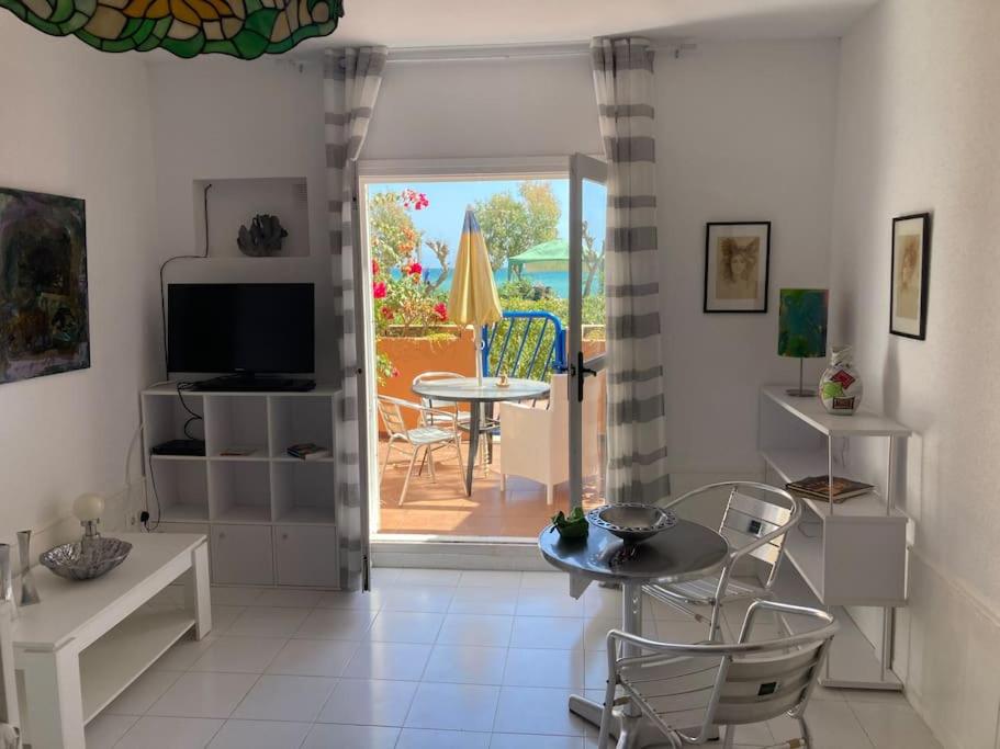 ein Wohnzimmer mit einem Tisch und Stühlen sowie eine Terrasse in der Unterkunft Estudio Naturista vista al mar in Vera