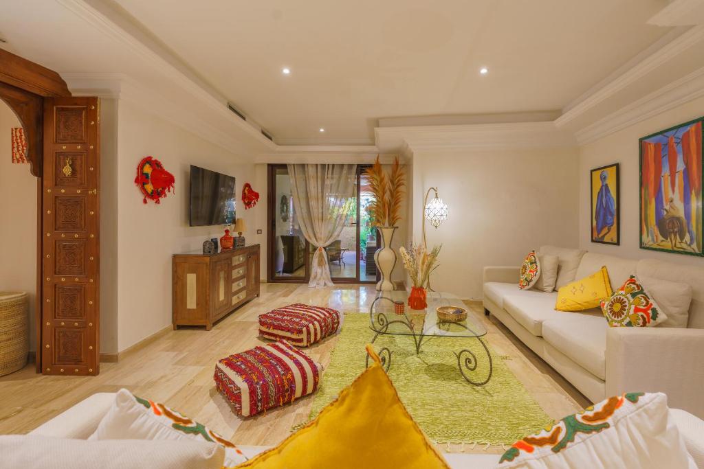 uma sala de estar com um sofá e uma mesa em Résidence piscine avec terrasse privé em Marrakech