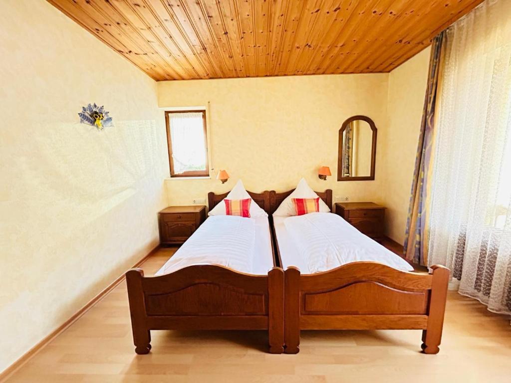 a bedroom with a bed with a wooden ceiling at Gästehaus Herzog in Uhldingen-Mühlhofen