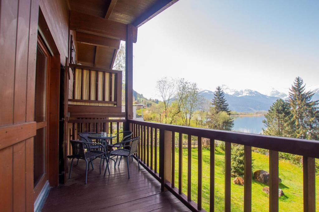 einen Balkon mit Tischen und Stühlen und Seeblick in der Unterkunft Lake and Mountain View in Zell am See