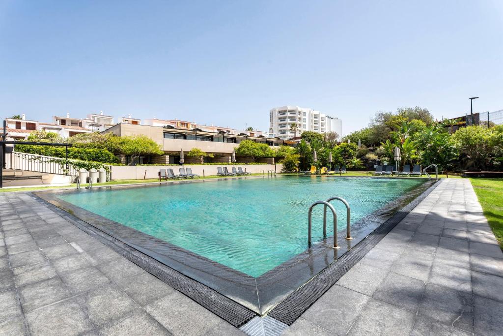 a large swimming pool with blue water in a city at Villa Verano in San Miguel de Abona