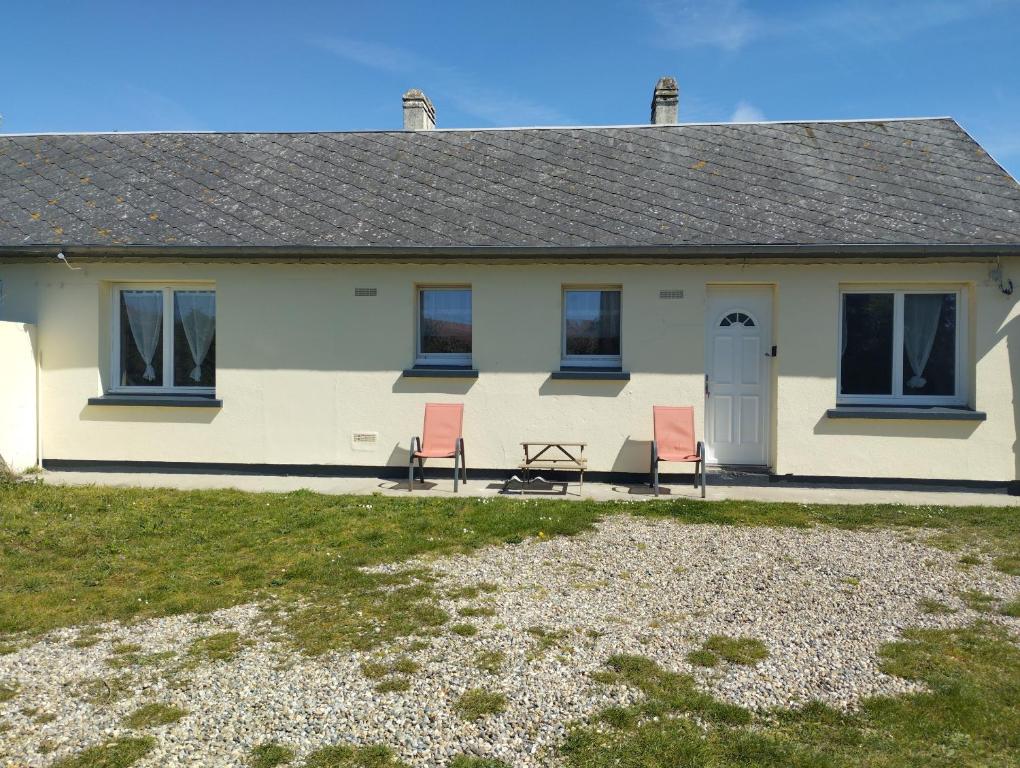 una casa con due sedie e un tavolo di fronte di Le Bol d'Air a Cayeux-sur-Mer