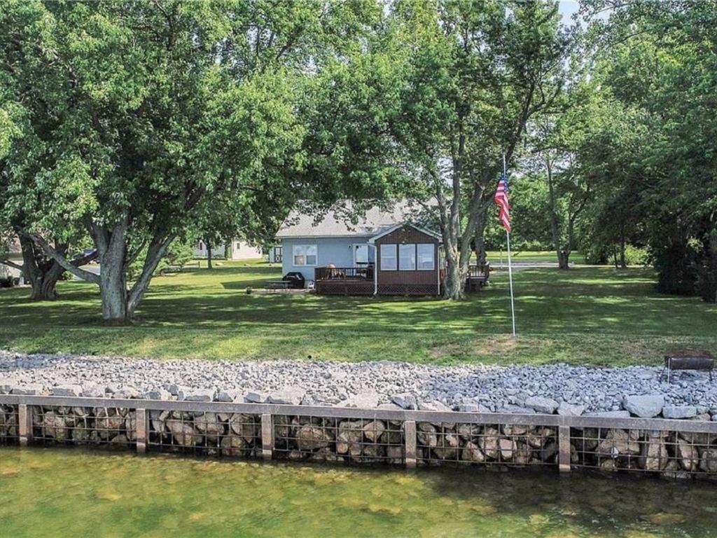 una casa en un parque con una bandera junto a un río en Cottage on Lake Ontario en Waterport