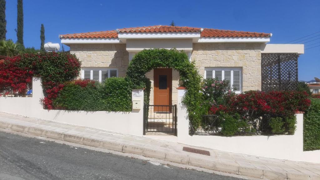 a house with flowers on the side of a street at Villa Best Holiday- breathtaking sea views, amazing garden, private pool, BBQ, next to CORAL BAY, Lower Peyia, Paphos in Peyia