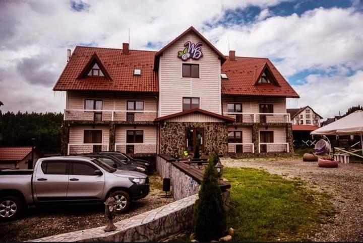 a truck parked in front of a large house at Whiteberry Studio in Bukovel