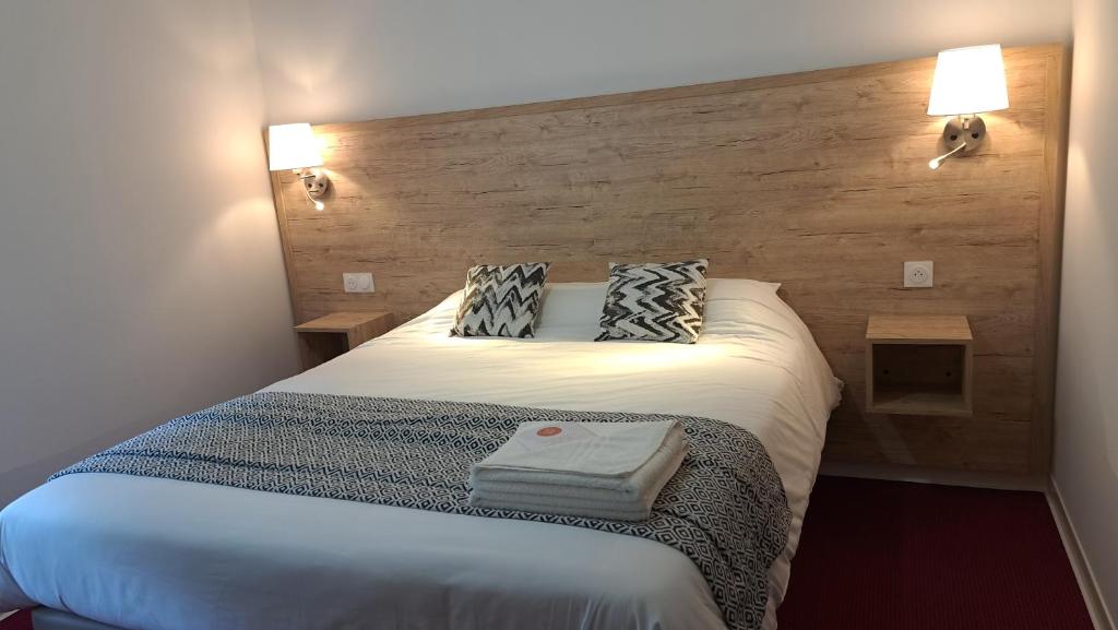 um quarto com uma cama branca e 2 almofadas em Abor Hôtel, Mont de Marsan em Saint-Pierre-du-Mont
