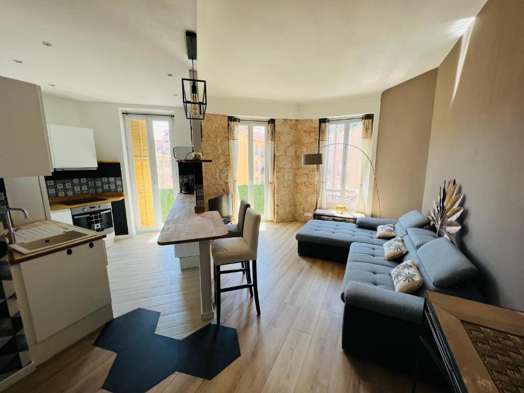 un salon avec un canapé bleu et une cuisine dans l'établissement Joyau rare port de Nice, à Nice