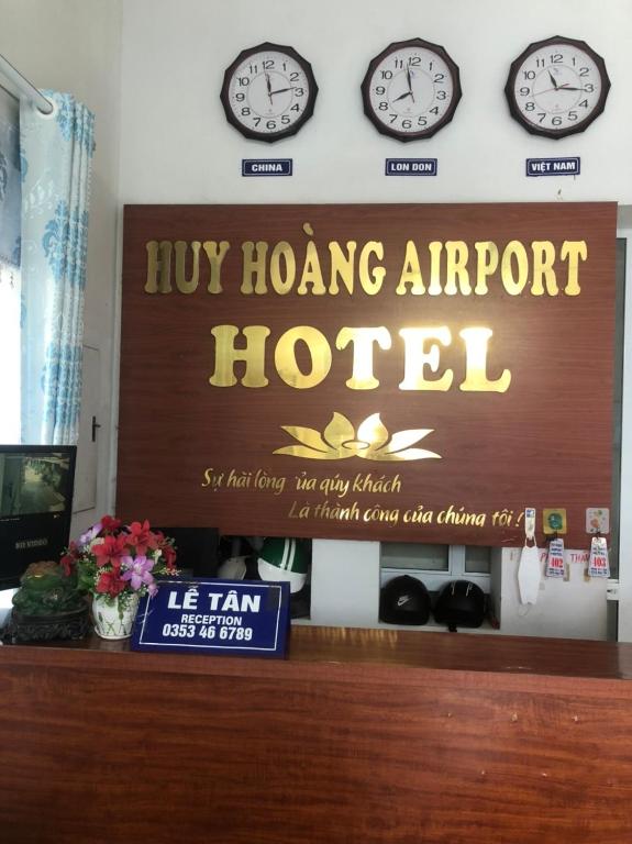 ein Schild für ein hong airport hotel mit Uhren an der Wand in der Unterkunft Ks Huy Hoang Airport in Hanoi