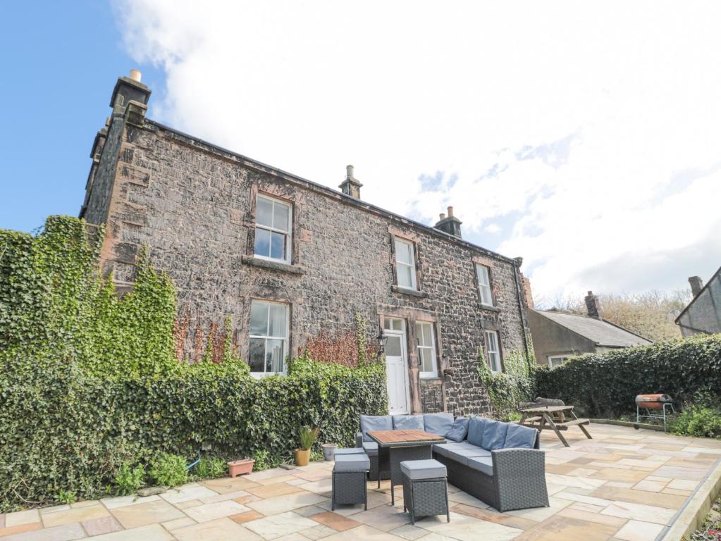 a brick house with a couch and a table in front of it at Jubilee House in Alnwick