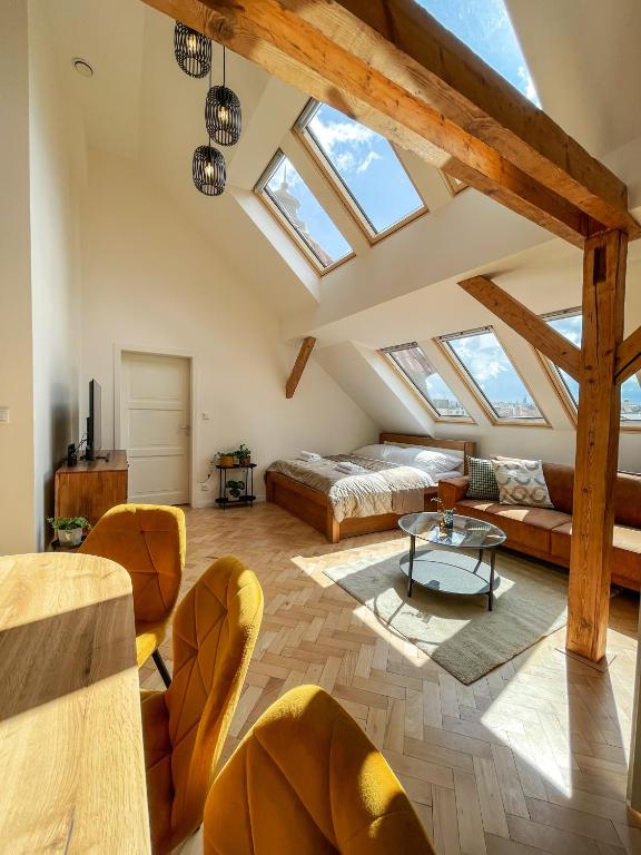 a attic living room with skylights and a table and chairs at Štupartská 9 - Old Town Residence in Prague