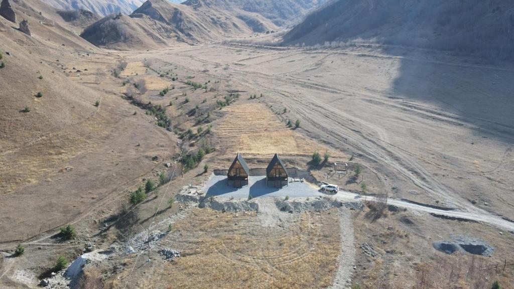 an aerial view of two temples on a mountain at Gagma chalets in Kazbegi