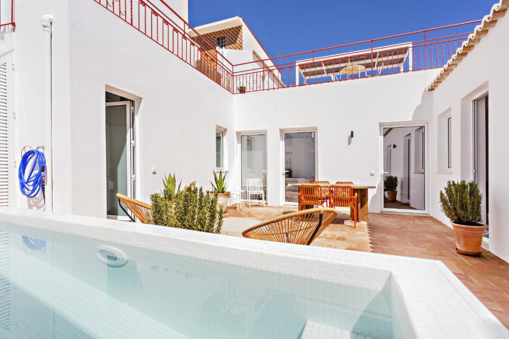 eine Villa mit einem Pool und einer Terrasse in der Unterkunft Casa Rosa in Vila Real de Santo António