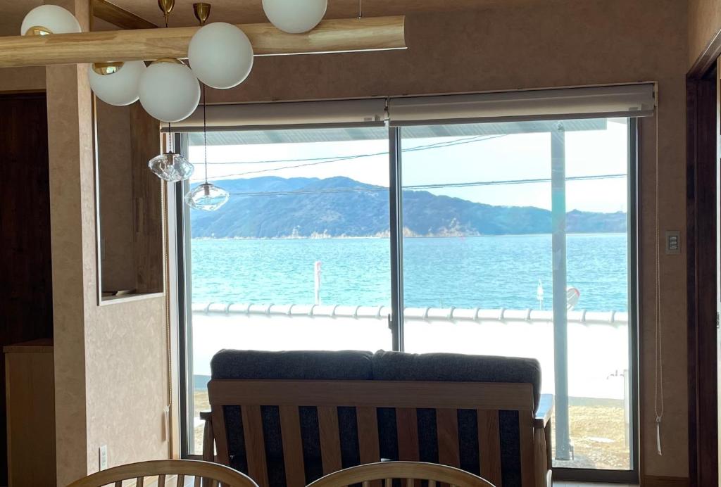 uma sala de jantar com vista para o oceano em Sunset Villa 悠生凪 ”Yunagi” em Kose