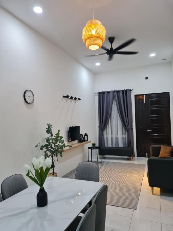 a living room with a table and a ceiling fan at The Bunga and The Daun Housestay 2 in Sungai Besar