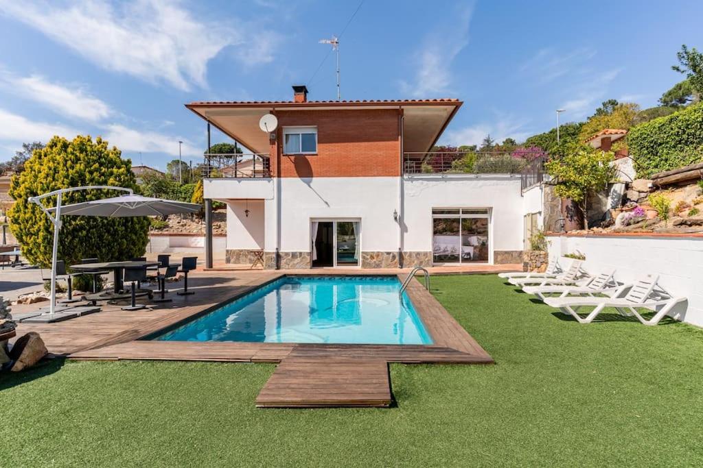 eine Villa mit einem Pool und einem Haus in der Unterkunft Villa Paraíso in Vidreres