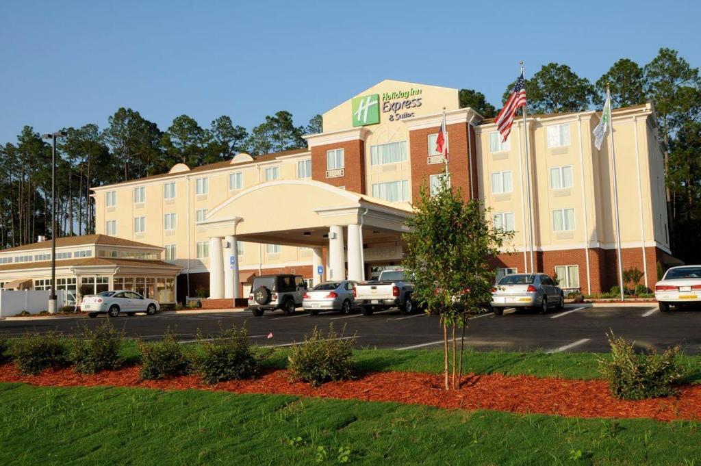 un hotel con coches estacionados en un estacionamiento en Holiday Inn Express Hotel & Suites Bainbridge, an IHG Hotel, en Bainbridge