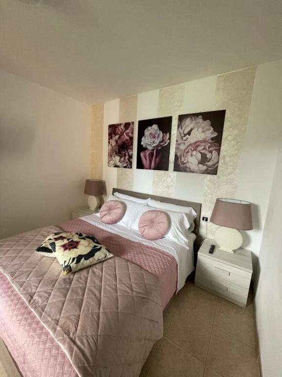 - une chambre avec un lit doté de draps roses et d'oreillers roses dans l'établissement Peonia Apartment - appartamento vista lago, à Lezzeno