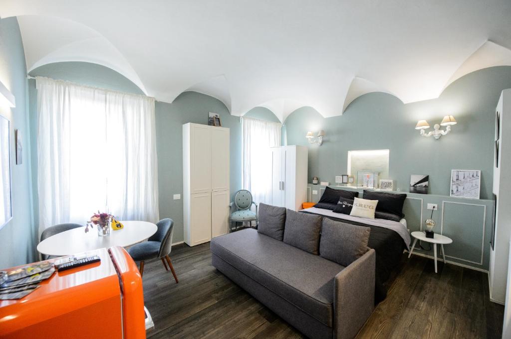 a room with a bed and a couch and a table at COTTON CANDY TORTELLINOSUITE Modena in Modena